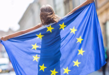 Objavljen je razpis za četrti mandat mladinskega podnebnega delegata Republike Slovenije EU Flag. Cute happy girl with the flag of the European Union. Young teenage girl waving with the European Union flag in the city.