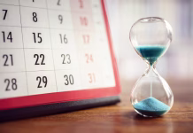 Ali znate pravilno zapisati datum in uro? Hour glass and calendar concept for time slipping away for important appointment date, schedule and deadline
