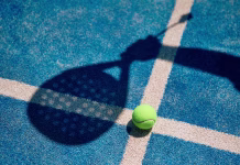 Padel: šport, ki je osvojil svet Paddle tennis ball with the player's shadow above. Copy space.
