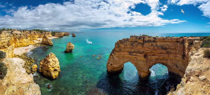 Praia da Marinha, beautiful beach Marinha in Algarve, Portugal. Navy Beach (Praia da Marinha) with flying seagulls over the beach, located on the Atlantic coast in Lagoa Municipality, Algarve.