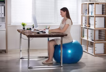 Ali je sedenje na žogi manj škodljivo kot na stolu? Smiling Young Businesswoman Sitting On Fitness Ball Using Computer