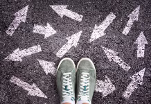 Kako izbrati pravo gimnazijo? Je res boljše izbrati ‘lažjo’ Sneaker shoes and arrows pointing in different directions on asphalt ground, choice concept