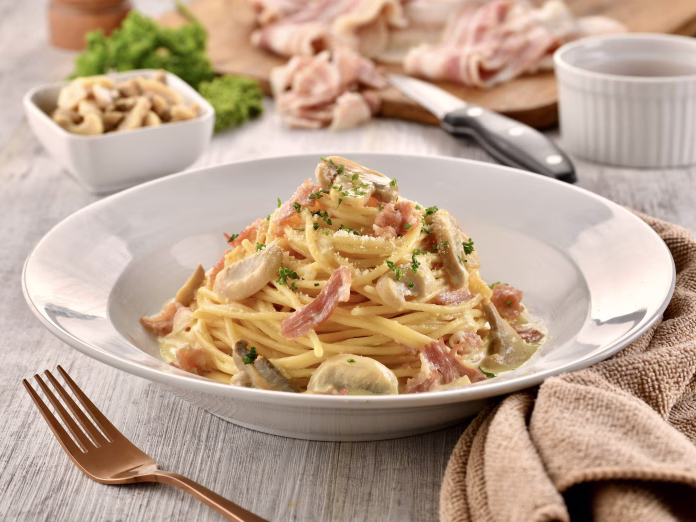 SPAGHETTI ALLA CARBONARA with mushroom and fork served in dish isolated on wooden table side view of italian fast food