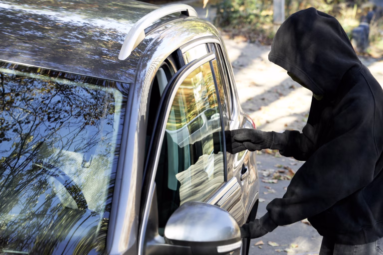 Thief breaking into modern auto. Car hijacking