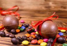 Teh čokoladnih jajčk gostje ne bodo pozabili (in želeli bodo recept) Chocolate easter eggs and multicolored candies on rustic wooden table