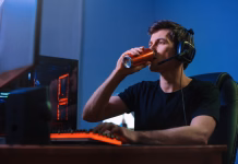 POZOR: Ta sestavina iz energijskih pijač in prehranskih dodatkov ima lahko usodne posledice Cyber sport. Professional cybersport player training or playing online video game on his PC late at night, drinking caffeine energy drink to concentrate, focus on game. Team play. Games addiction