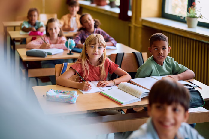Diverse schoolkids listening their teacher on a class at elementary school.