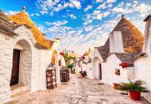 Pozabite na Rim: To italijansko mesto vas bo osvojilo že prvi večer! Famous Trulli Houses during a Sunny Day with Bright Blue Sky in Alberobello, Puglia, Italy