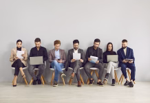 18-milijonski projekt, ki bo pomagal mladim najti delo Happy young professional business people, group of applicants are sitting on chairs, waiting for interview, sitting in line with laptops, notebooks and other resources. Staffing employment concept.