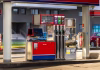 Znano, če je vredno počakati do jutri! Nove cene goriv bodo razveselile … Ljubljana, Slovenia December 30, 2025, fuel pump at gas station, a close-up view of a modern fuel pump at a gas station with multiple nozzles for different fuel types, digital display showing price and liters, and safety signs visible, with cars and buildings in the background