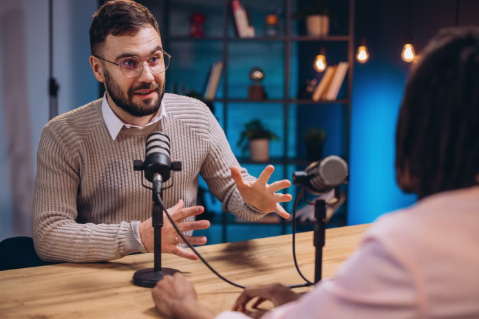 Professional podcast duo collaborating, speaking into microphones while recording engaging audio content in modern studio setting