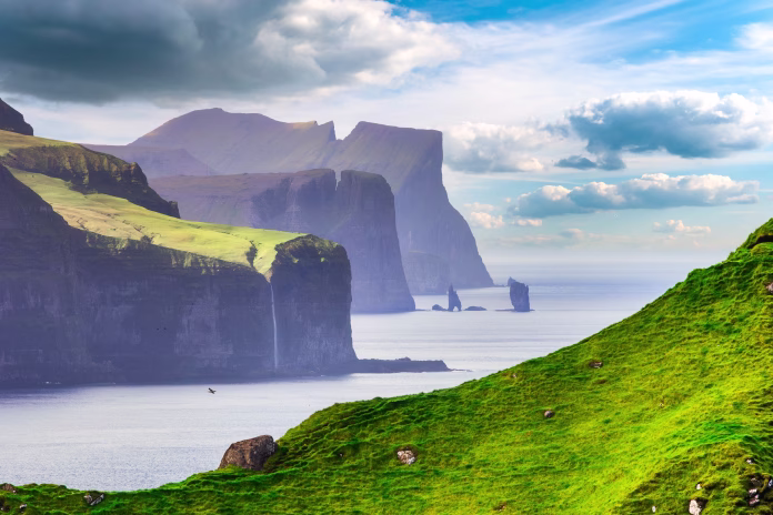 Risin og Kellingin rock formations on the coast of Streymoy Island view from Kalsoy Island, Faroe Islands, Denmark.