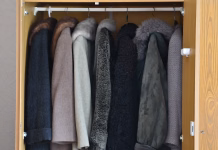 Ta preprost trik vam lahko podvoji prostor v omari Women's wool and fur coats hanging in the wardrobe.
