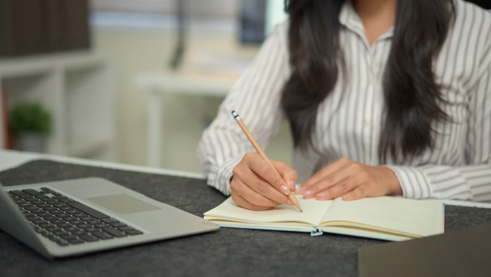 Closeup businesswoman hand working with writing on notebook.