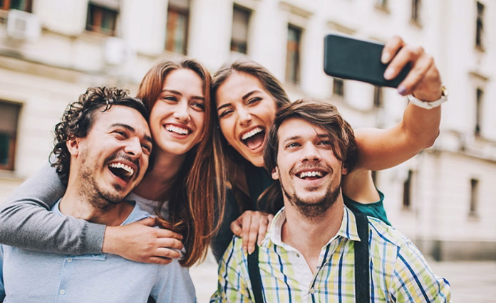 Two couples making selfie Two couples outdoors in the city in a funny pose for selfie