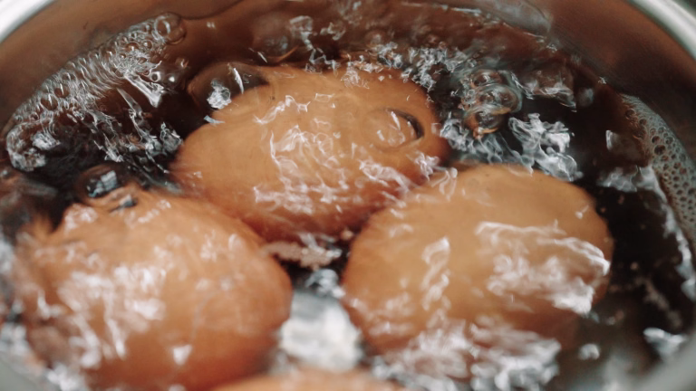 The eggs are boiling in a pot of boiling water.