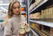 Botulizem: Redka, a izjemno nevarna zastrupitev, ki jo lahko preprečite Woman buys stew in cans in a supermarket, provisions and shelf-stable food products