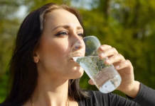 Miti o gazirani vodi: ali mehurčki res topijo kilograme? Woman with glass of sparkling water, sunny summer day