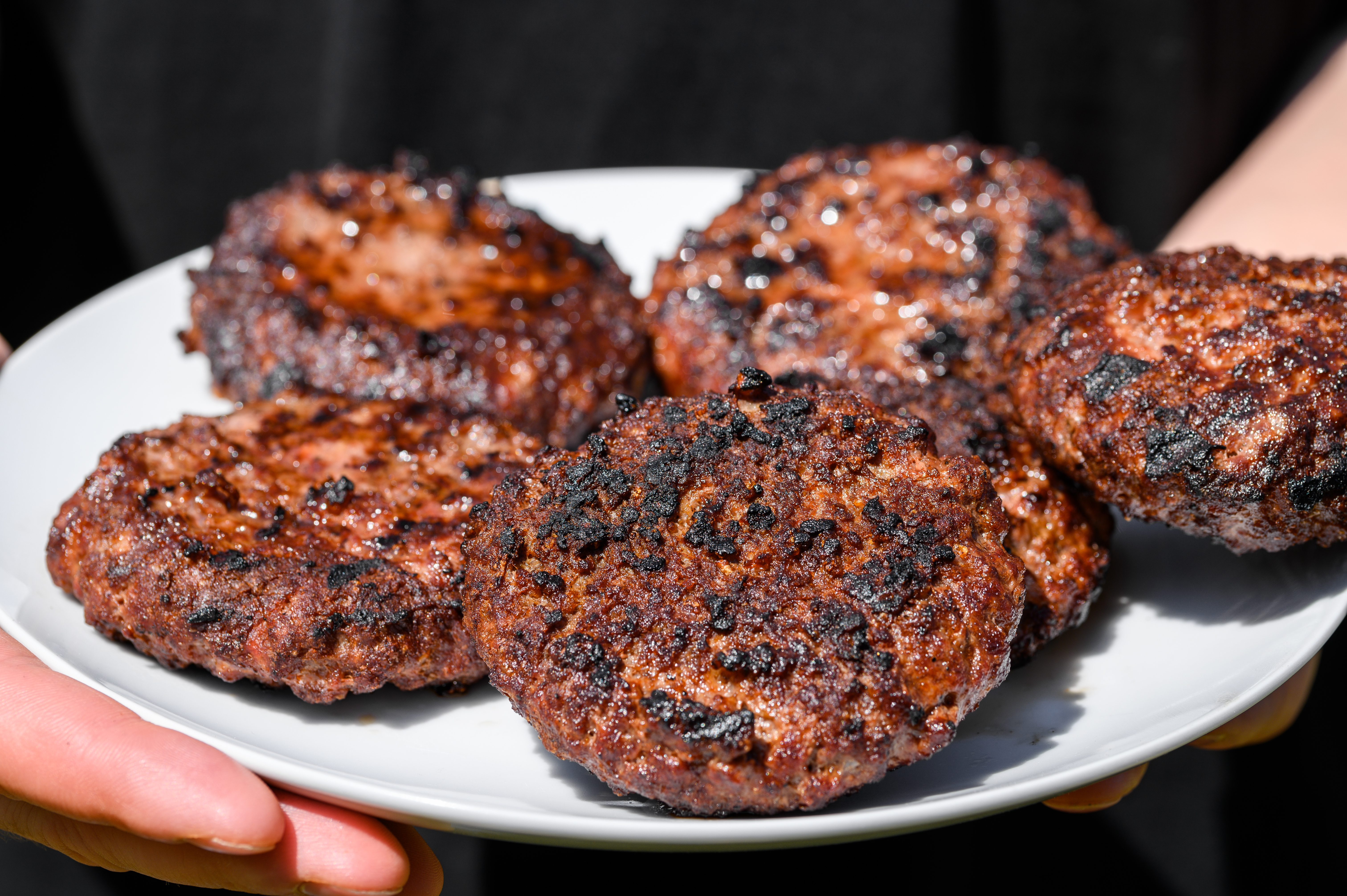 Burnt hamburgers on a plate, polycyclic aromatic hydrocarbons, carcinogenic grilled food