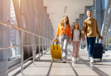 Potovanja kot terapija? Znanstveniki pravijo, da imajo lahko učinek proti staranju Caucasian family walking together at airport with luggage, holding hands and smiling in bright corridor, showing cheerful lifestyle, bonding and happy holiday travel