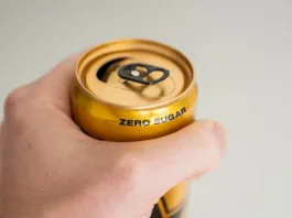 Ali so zero pijače manj škodljive za zobe? close up of hand holding a zero sugar soda can.