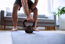To se zgodi, če trenirate brez obutve: posledice, ki jih niste pričakovali Closeup of man grabing kettlebell during home workout exercises