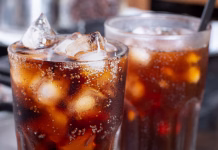 Nasvet za vroče dni: koliko minut pustiti pijačo v zamrzovalniku? cola with crushed ice in glass and there is water droplets around. cool black fresh drink.