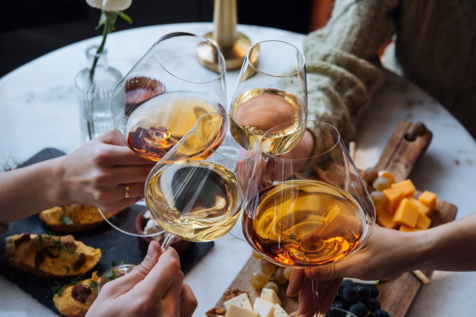 Friends having a dinner party with different kinds of appetizers and wine.