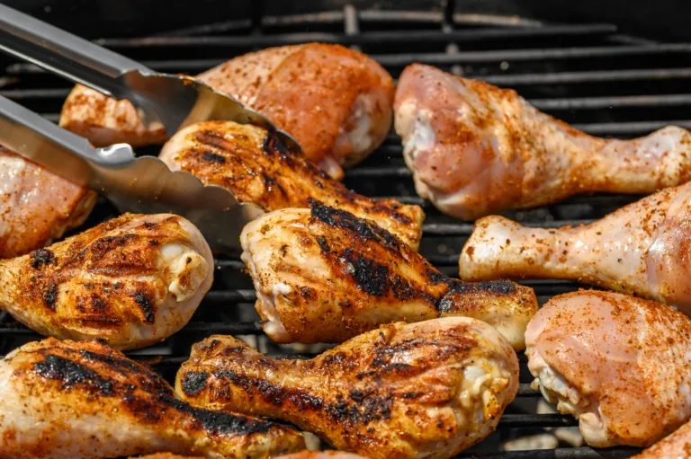 Juicy pieces of chicken charred on a very hot charcoal grill