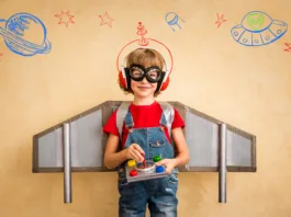 Kid pilot playing with toy jetpack at home. Success and leader concept