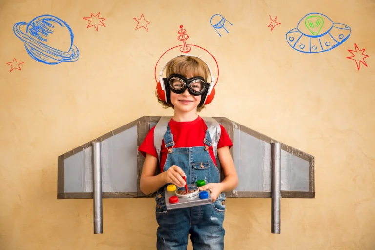 Kid pilot playing with toy jetpack at home. Success and leader concept