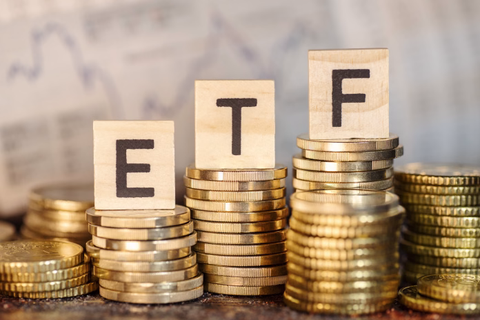 several-stacks-with-coins-and-the-term-etf-and-a-chart-with-stock-prices-stockpack-istock Several stacks with coins and the term ETF and a chart with stock prices.