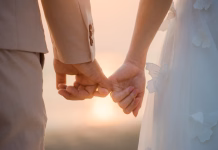 Ko podvomite o poroki: to so rdeči signali, da boste odločitev obžalovali The bride and groom use the little finger together. lovely couple hold hand with sunset background