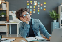 Razlogi, zaradi katerih se v službi dolgočasite: poznati bi jih moral vsak delodajalec Tired woman is sleeping at desk in workplace then waking up and working with laptop feeling sleepy and exhausted. Modern technology and deadline concept.