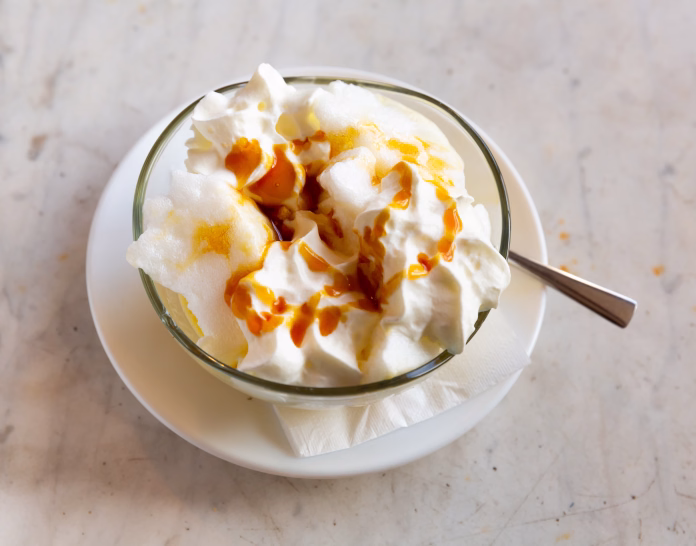Traditional french dessert, ile flottante decorated with caramel and whipped cream