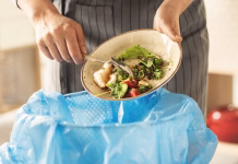 Češka, Danska in Izrael: tako so se s problemom zavržene hrane spopadle te države Woman scraping leftover food from plate into trash bin in kitchen