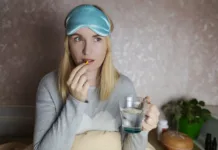 To so učinki, ki jih ima dodatek melatonina na telo: Vse kaže na to, da ni le uspavalni hormon A woman cannot fall asleep and wants to drink a capsule with melatonin, a sleeping pill. Regulation of biological rhythms. Manifestations of jitlag or insomnia.