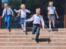 Beautiful school children active and happy on the background of school in uniform