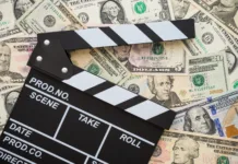 Kultura filmski predelav: zakaj Hollywood reciklira? Cinema clapperboard on stack US dollars banknote bill background - Movie entertainment industry to make money concept.