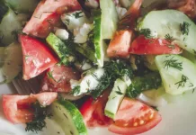 Kaj so gospodinje iz Jugoslavije dodajale solati iz paradižnika in kumar? Zaradi te sestavine je bila neprimerljivo okusnejša … Cucumber and tomato salad with herbs, close-up.