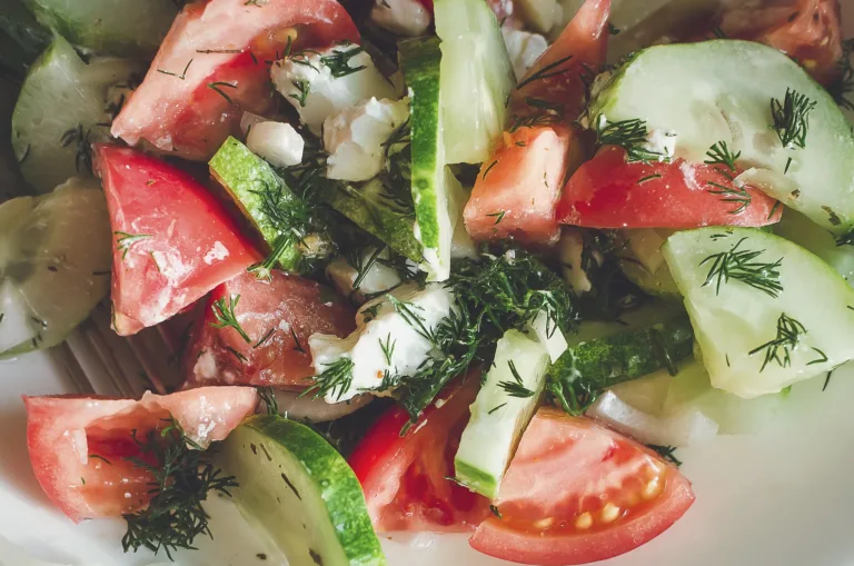 Cucumber and tomato salad with herbs, close-up.
