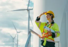 Slovenka med 12 najboljšimi inženirkami sveta female engineer working outdoor with safety at wind turbines clean energy power station background, worker people with renewable energy technology for future concept.