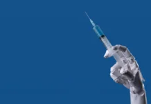 Novo cepivo proti koronavirusu je v celoti zasnovala umetna inteligenca Future of Medicine: Robotic Arm with Syringe, AI Healthcare Concept