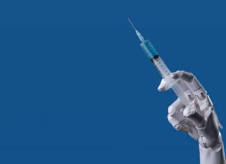 Novo cepivo proti koronavirusu je v celoti zasnovala umetna inteligenca Future of Medicine: Robotic Arm with Syringe, AI Healthcare Concept