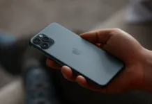 Se nakup rabljenega telefona splača? Na to morate biti pozorni, da vas ne prinesejo okoli Minsk, Belarus - December 11, 2019: A man holds a new model apple iphone backside up closeup . Illustrative editorial