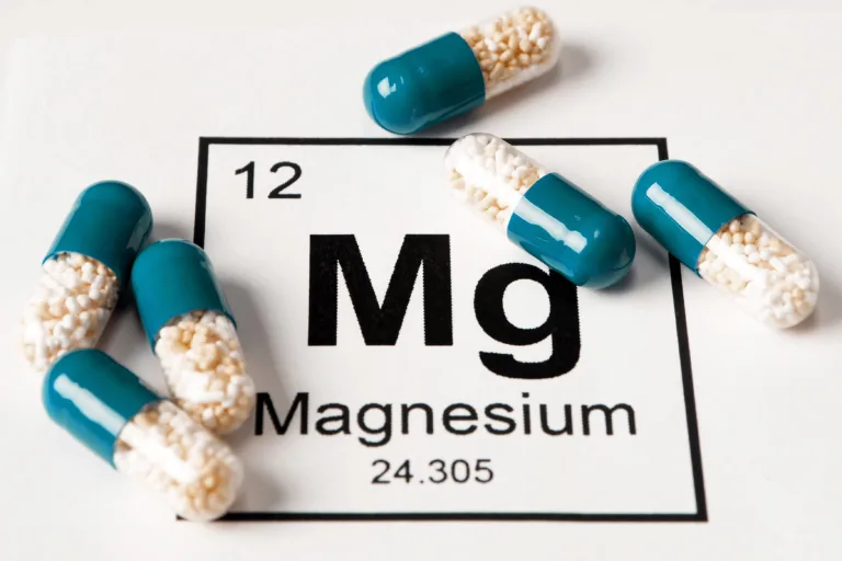 Pills with mineral Mg (magnesium) on a white background with an inscription from the chemical table.
