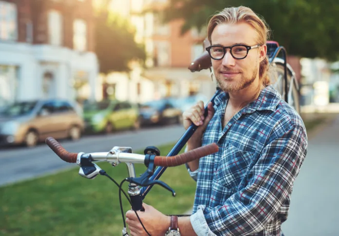 Portrait of blonde white man in the city with a bike