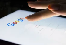 Želite vedeti, kdo vas je poiskal na Googlu? Tuaj so preprosti načini, kako to ugotoviti Sankt-Petersburg, Russia, November 8, 2017: A woman's hand is touching screen on tablet computer iPad Pro at night for searching on Google search engine. Google is the most popular Internet search engine in the world. Photo taken at company office.