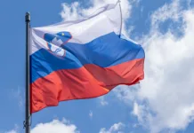 Ko Slovenijo praznuješ v Parizu: Praznovati dan državnosti daleč od doma Slovenian national flag waving on blue sky background. Republic of Slovenia, SL