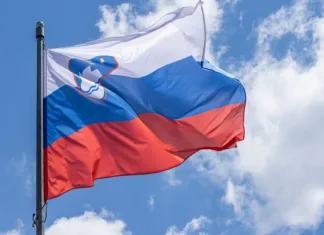Ko Slovenijo praznuješ v Parizu: Praznovati dan državnosti daleč od doma Slovenian national flag waving on blue sky background. Republic of Slovenia, SL